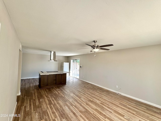 unfurnished living room with ceiling fan and light hardwood / wood-style flooring