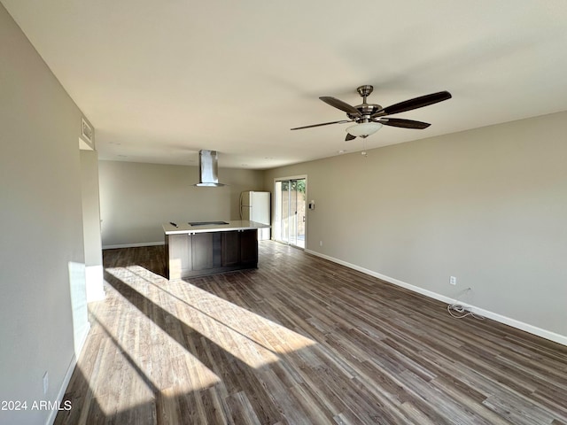 unfurnished living room with ceiling fan and dark wood-type flooring