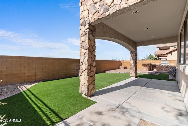 view of yard with exterior kitchen and a patio area