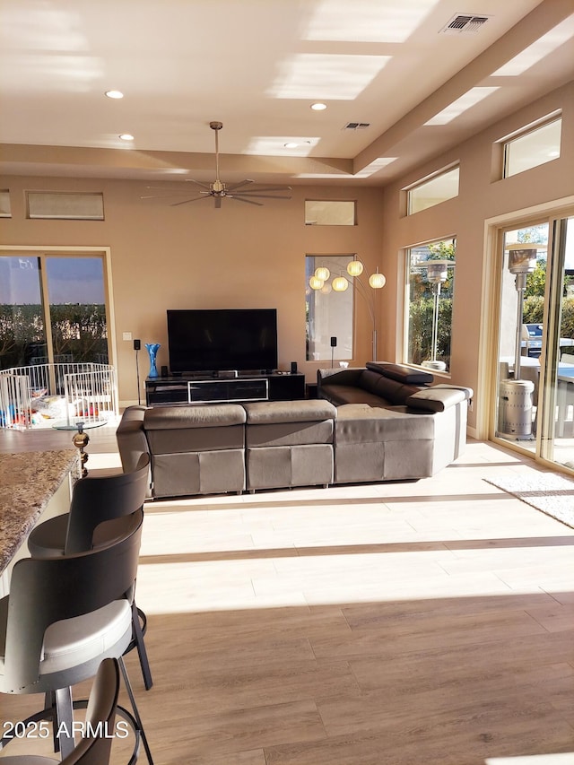 living room featuring ceiling fan and light hardwood / wood-style floors