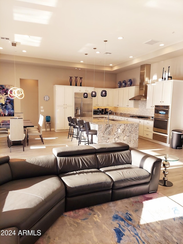 living room featuring sink and light hardwood / wood-style flooring