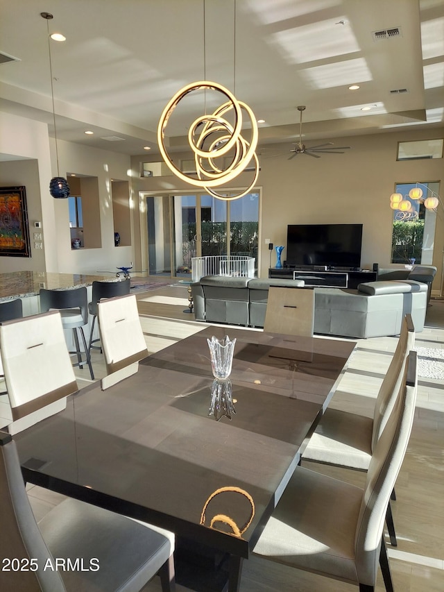 dining space featuring ceiling fan with notable chandelier