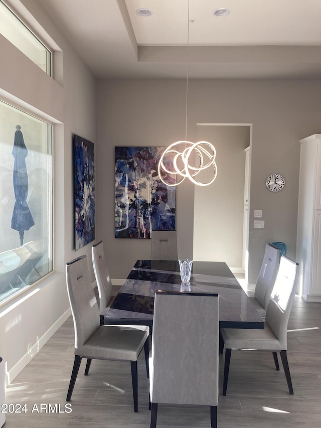 dining area with light hardwood / wood-style flooring and a chandelier