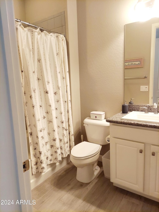 bathroom with hardwood / wood-style floors, vanity, toilet, and a shower with shower curtain