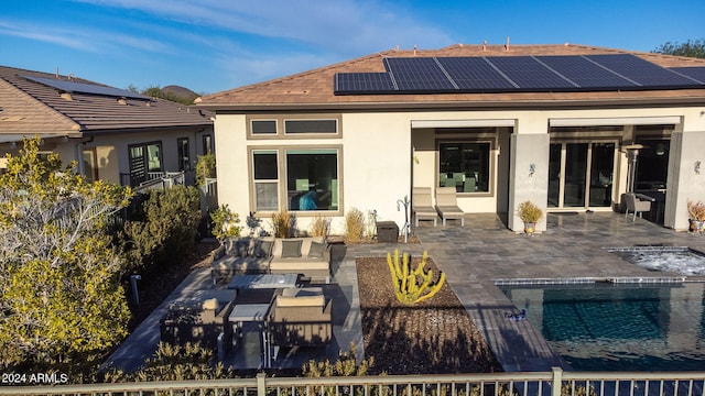 rear view of property featuring solar panels and a patio area