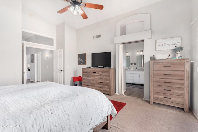 carpeted bedroom featuring connected bathroom, ceiling fan, and high vaulted ceiling