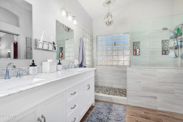 bathroom featuring tiled shower, vanity, hardwood / wood-style flooring, and a chandelier