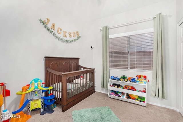 carpeted bedroom featuring a nursery area