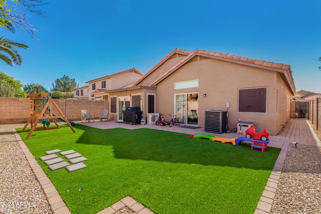 rear view of house featuring a playground, a patio area, a yard, and cooling unit