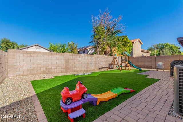 view of yard with a playground, a patio area, and central AC