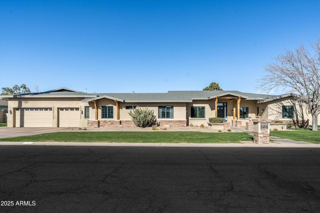 view of front of property featuring a garage and a front lawn