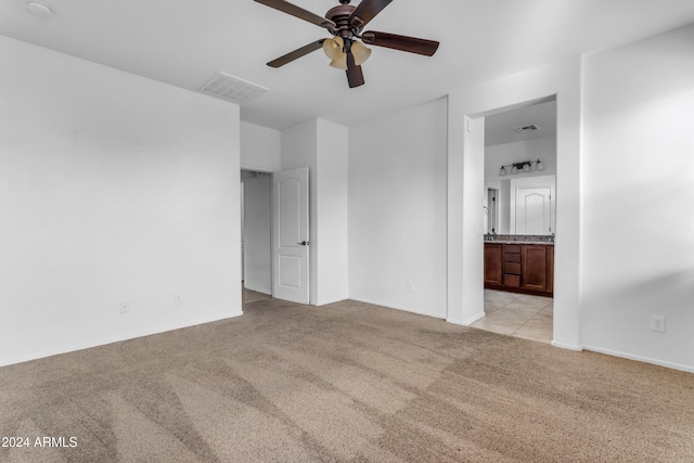 carpeted spare room featuring ceiling fan