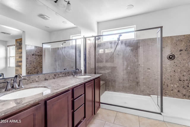 bathroom with tile patterned flooring, vanity, and walk in shower