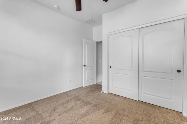 unfurnished bedroom featuring carpet, a closet, and ceiling fan