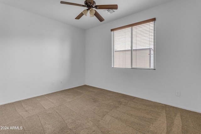 empty room featuring ceiling fan and carpet