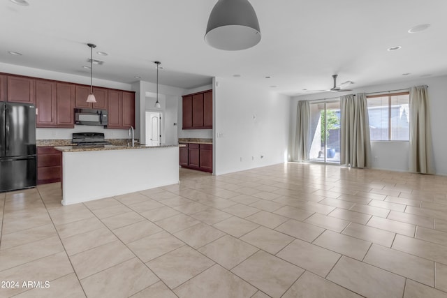 kitchen with ceiling fan, decorative light fixtures, a center island with sink, light tile patterned floors, and black appliances