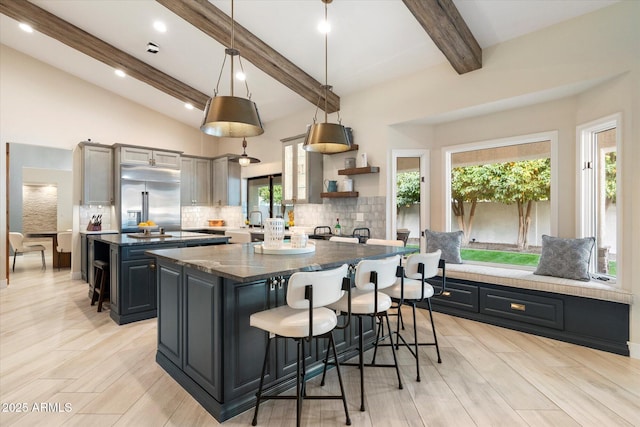 kitchen with a kitchen island, decorative backsplash, built in fridge, a kitchen breakfast bar, and open shelves