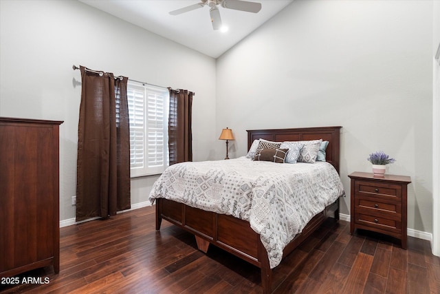 bedroom featuring dark wood finished floors, lofted ceiling, baseboards, and ceiling fan