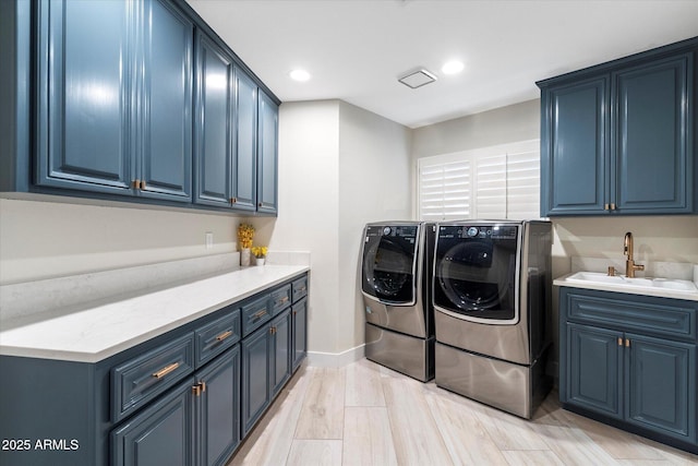 laundry area with a sink, baseboards, recessed lighting, cabinet space, and separate washer and dryer