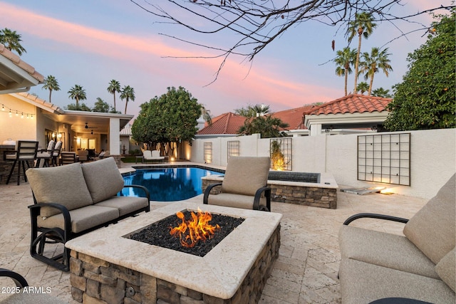 pool featuring an outdoor living space with a fire pit, a patio area, and fence