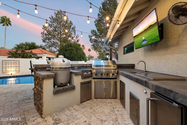 view of patio / terrace with a fenced in pool, fence, area for grilling, an outdoor kitchen, and a sink