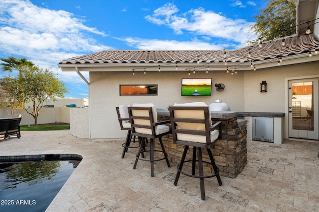 view of patio / terrace featuring area for grilling, a fenced in pool, outdoor wet bar, and fence