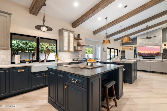 kitchen with decorative light fixtures, a kitchen bar, decorative backsplash, and a center island