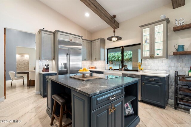 kitchen featuring open shelves, decorative backsplash, built in refrigerator, and a kitchen island