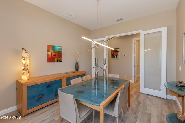 dining room with light wood finished floors, baseboards, and visible vents