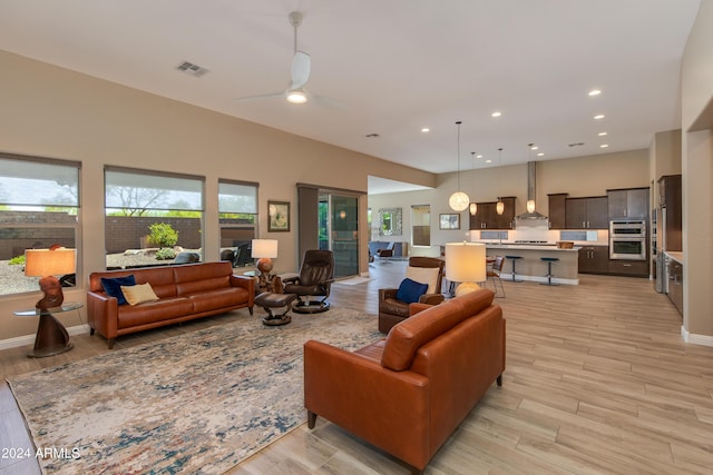 living area with light wood finished floors, visible vents, baseboards, ceiling fan, and recessed lighting