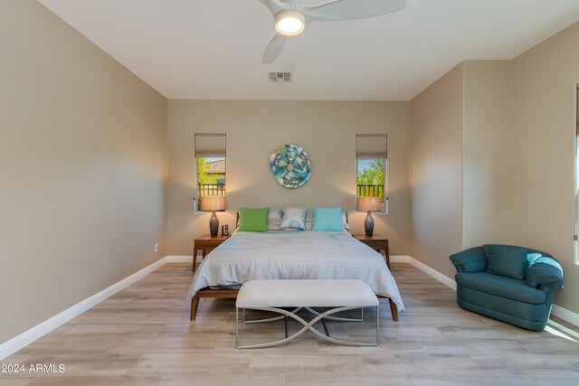 bedroom featuring a ceiling fan, baseboards, visible vents, and light wood finished floors