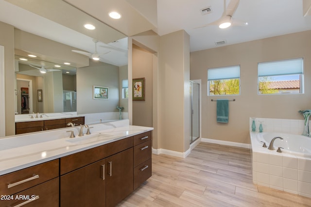 bathroom with ceiling fan, wood finished floors, vanity, a shower stall, and a bath