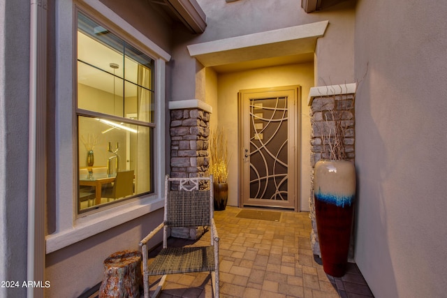 entrance to property with stone siding and stucco siding