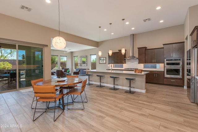 dining room featuring light wood-style floors, recessed lighting, visible vents, and baseboards