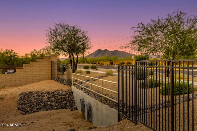 gate at dusk featuring fence and a mountain view