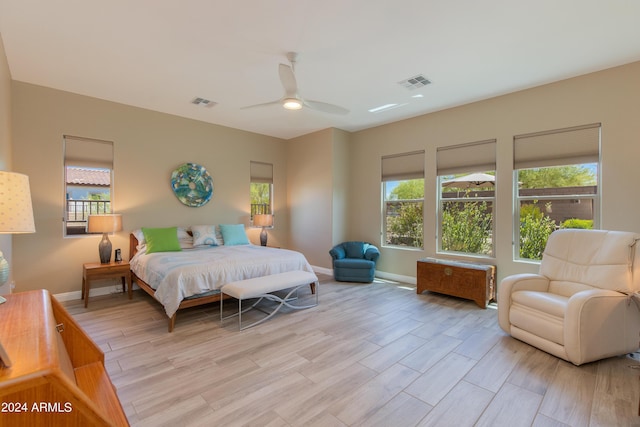 bedroom featuring light wood-style flooring, a ceiling fan, visible vents, and baseboards