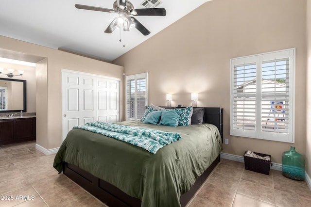 bedroom featuring light tile patterned flooring, ensuite bath, high vaulted ceiling, a closet, and ceiling fan