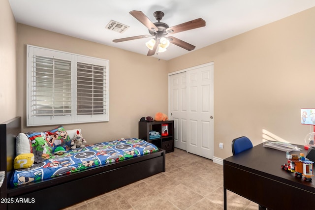 bedroom with ceiling fan, a closet, and light tile patterned floors