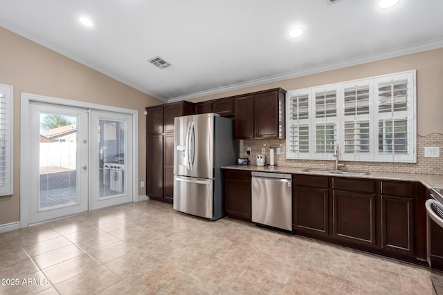 kitchen with vaulted ceiling, sink, stainless steel appliances, dark brown cabinets, and french doors