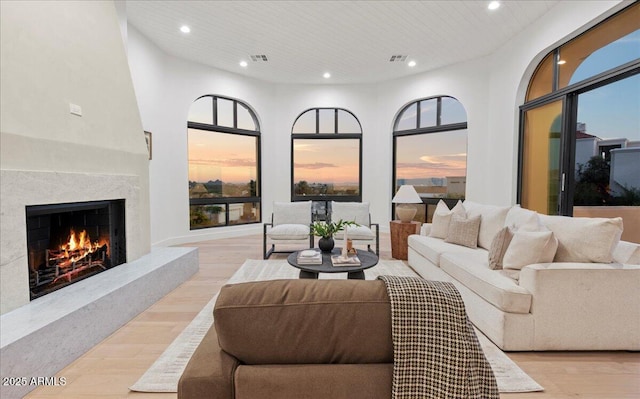 living area with a fireplace, recessed lighting, light wood-style floors, and visible vents