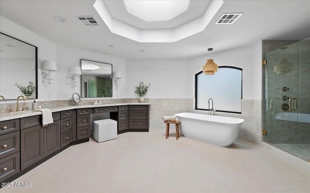 bathroom with double vanity, a sink, and visible vents