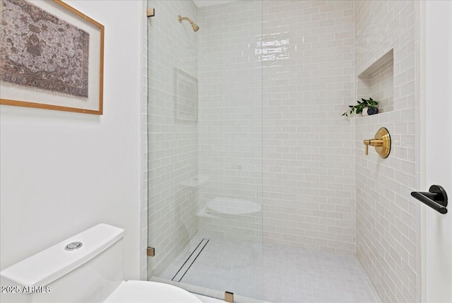 full bathroom featuring tiled shower and toilet