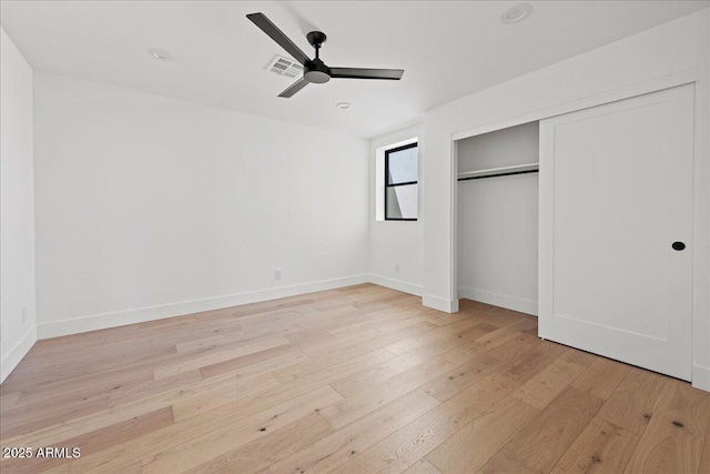 unfurnished bedroom with visible vents, light wood-style flooring, a closet, and baseboards