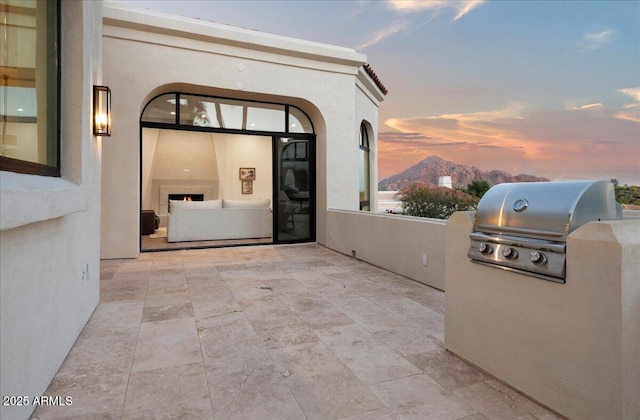 exterior space featuring a patio area, area for grilling, and stucco siding