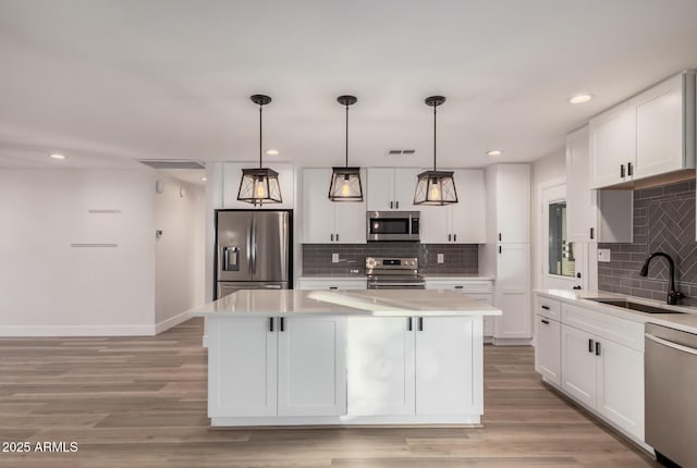 kitchen featuring a sink, light countertops, light wood-type flooring, and stainless steel appliances