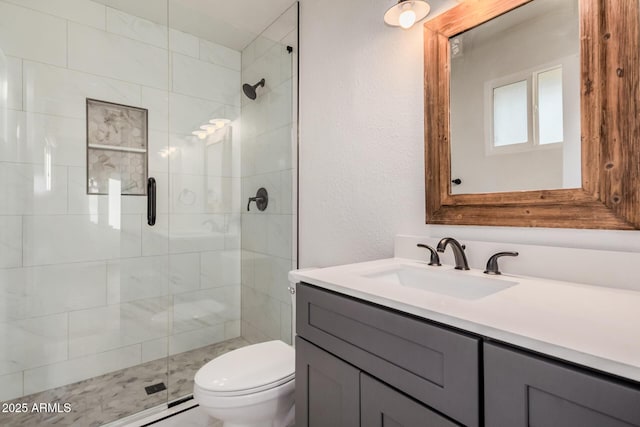 bathroom with a shower stall, toilet, vanity, and a textured wall