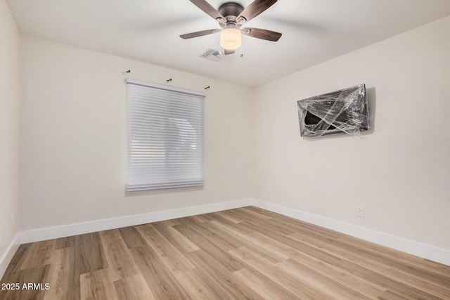 empty room featuring visible vents, baseboards, light wood-style floors, and ceiling fan