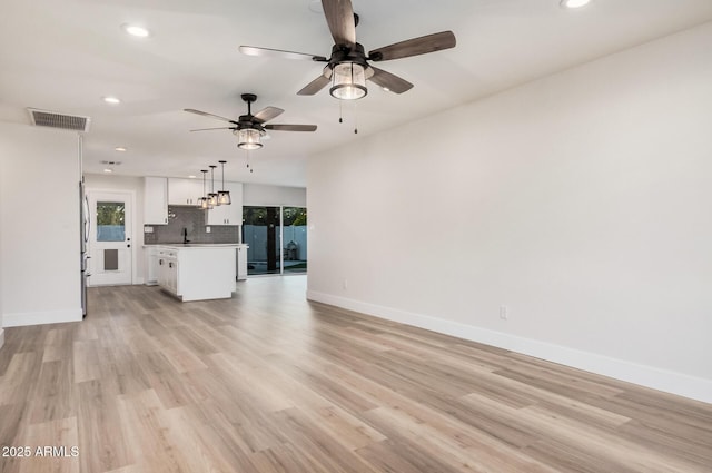 unfurnished living room with recessed lighting, visible vents, light wood-style flooring, and baseboards