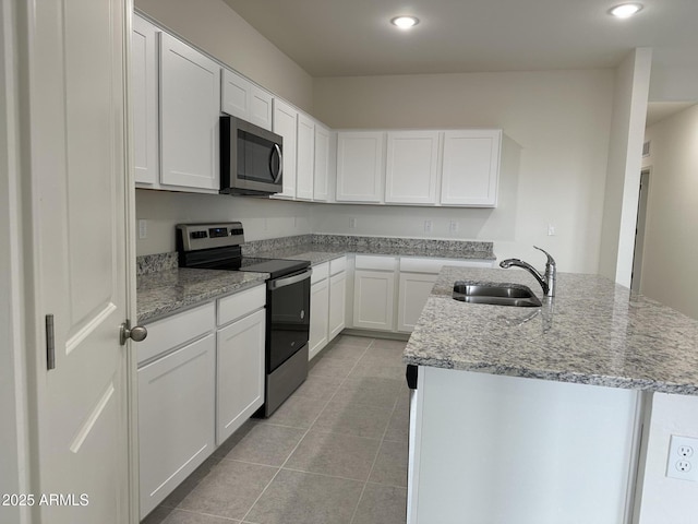 6064 E Artemis Dr, Florence, AZ 85132 - kitchen with stainless steel appliances, a sink, light tile patterned floors, a kitchen island with sink, and white cabinets