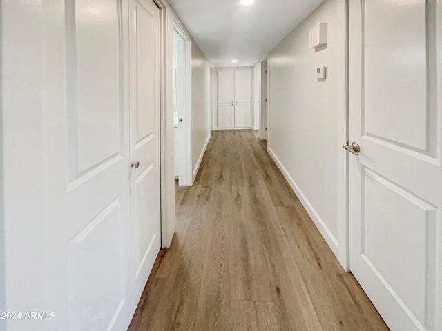 hallway with light hardwood / wood-style floors